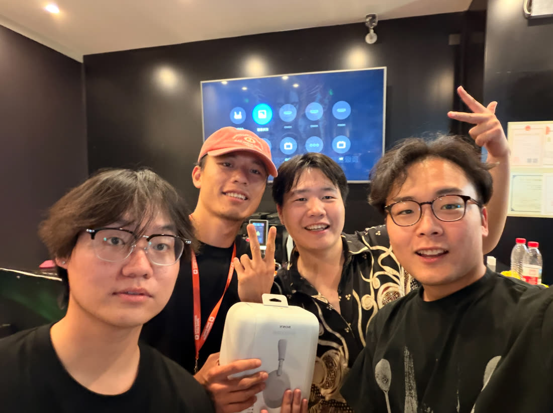 Team selfie with the Sony WH-1000XM6 prize at the Beijing net-café hackathon (Wangjing)